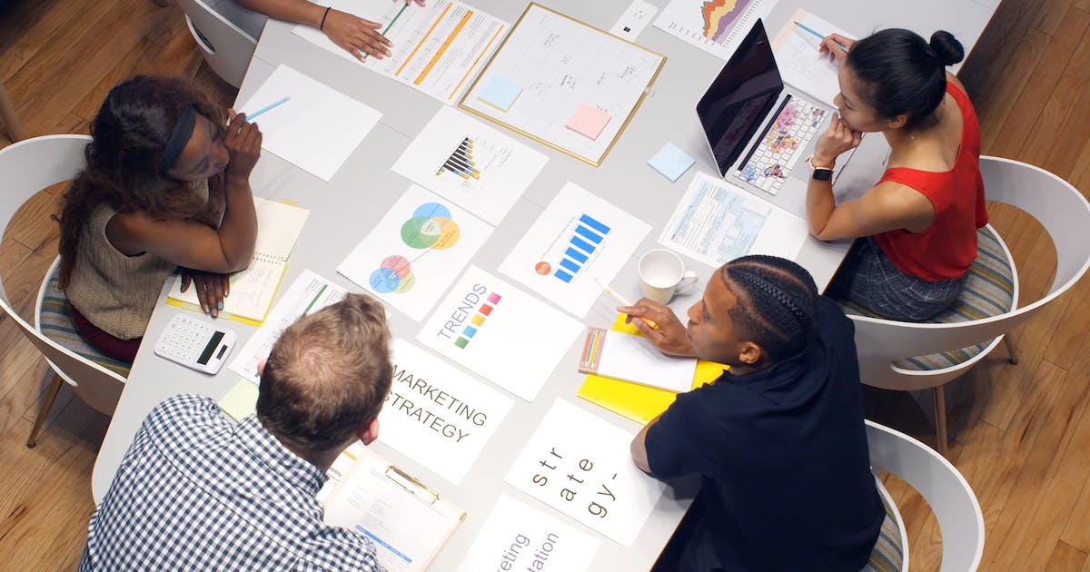 A marketing team reviewing charts and strategy documents around a table