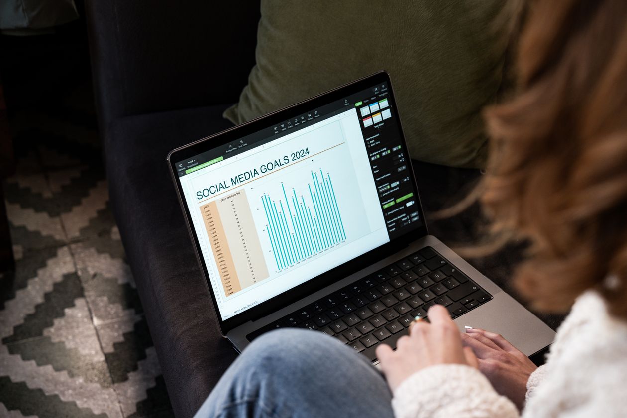 A marketer reviewing social media performance charts on a laptop